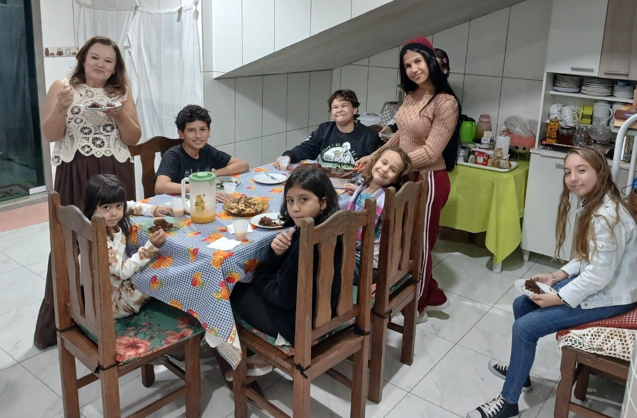 Adolescentes e crianças partilhando lanche em momento de comunhão