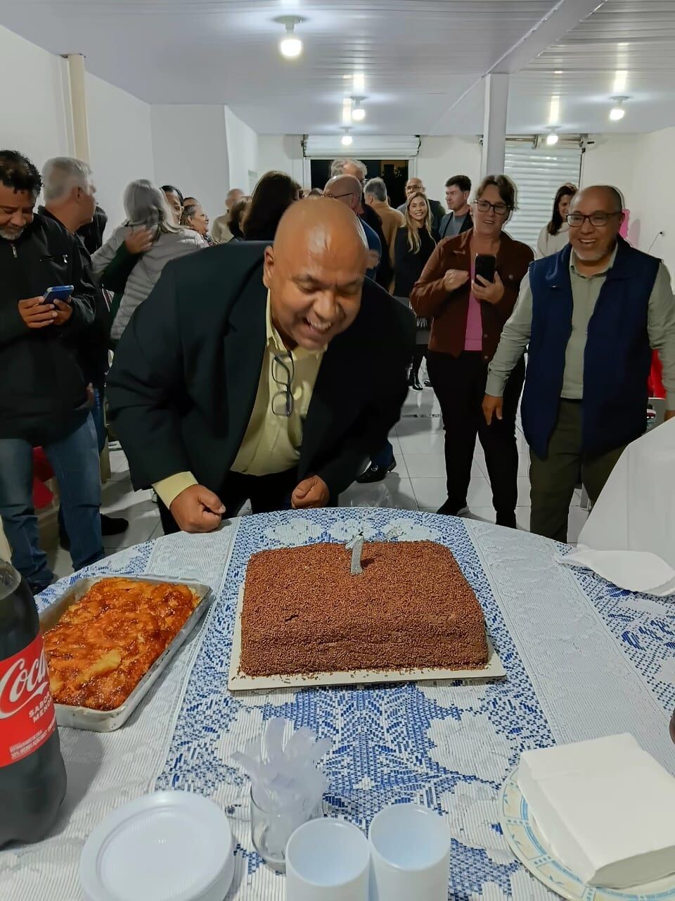 Aniversariante soprando a vela do bolo durante a celebração