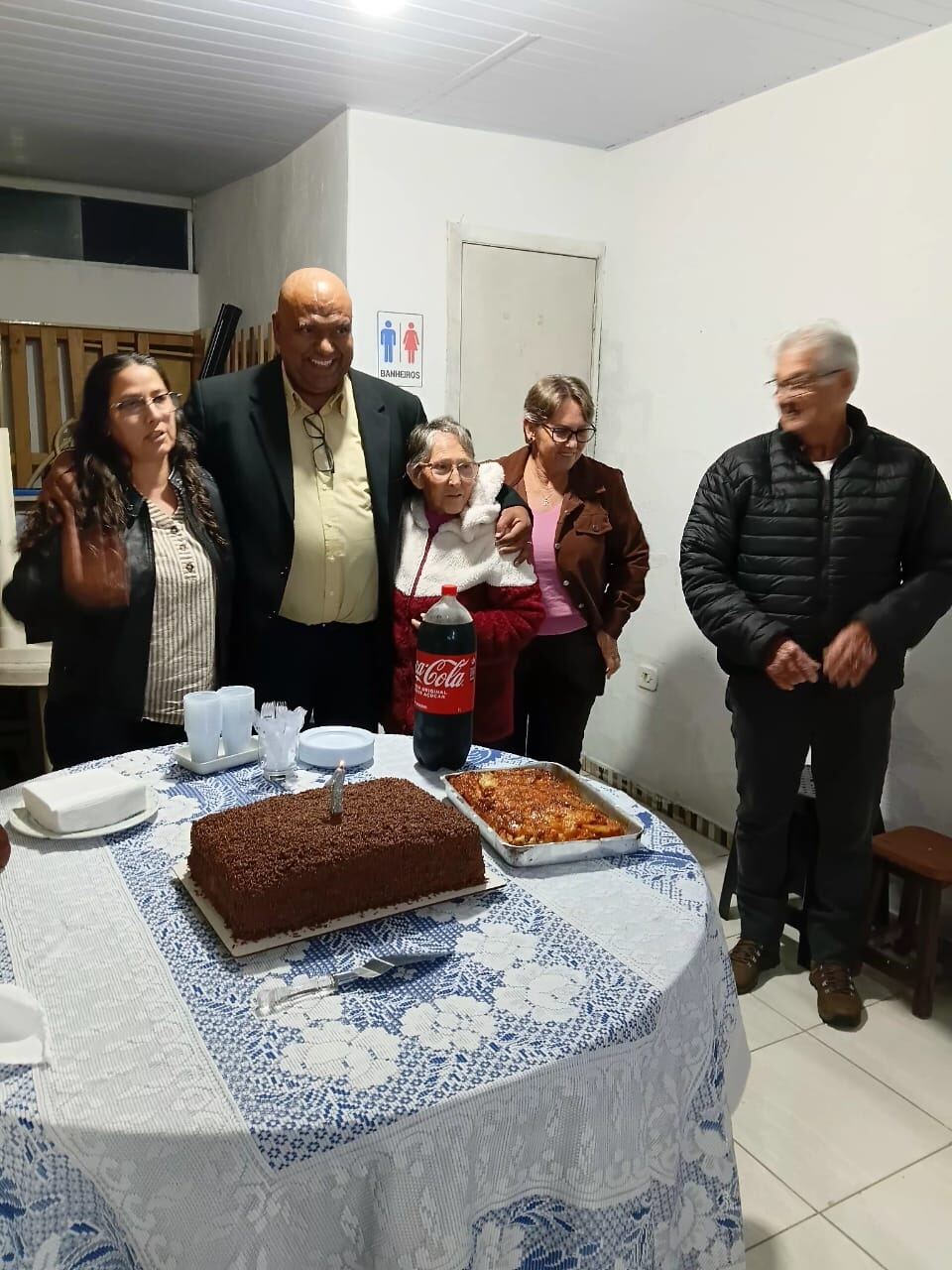 Família reunida ao redor do bolo de aniversário