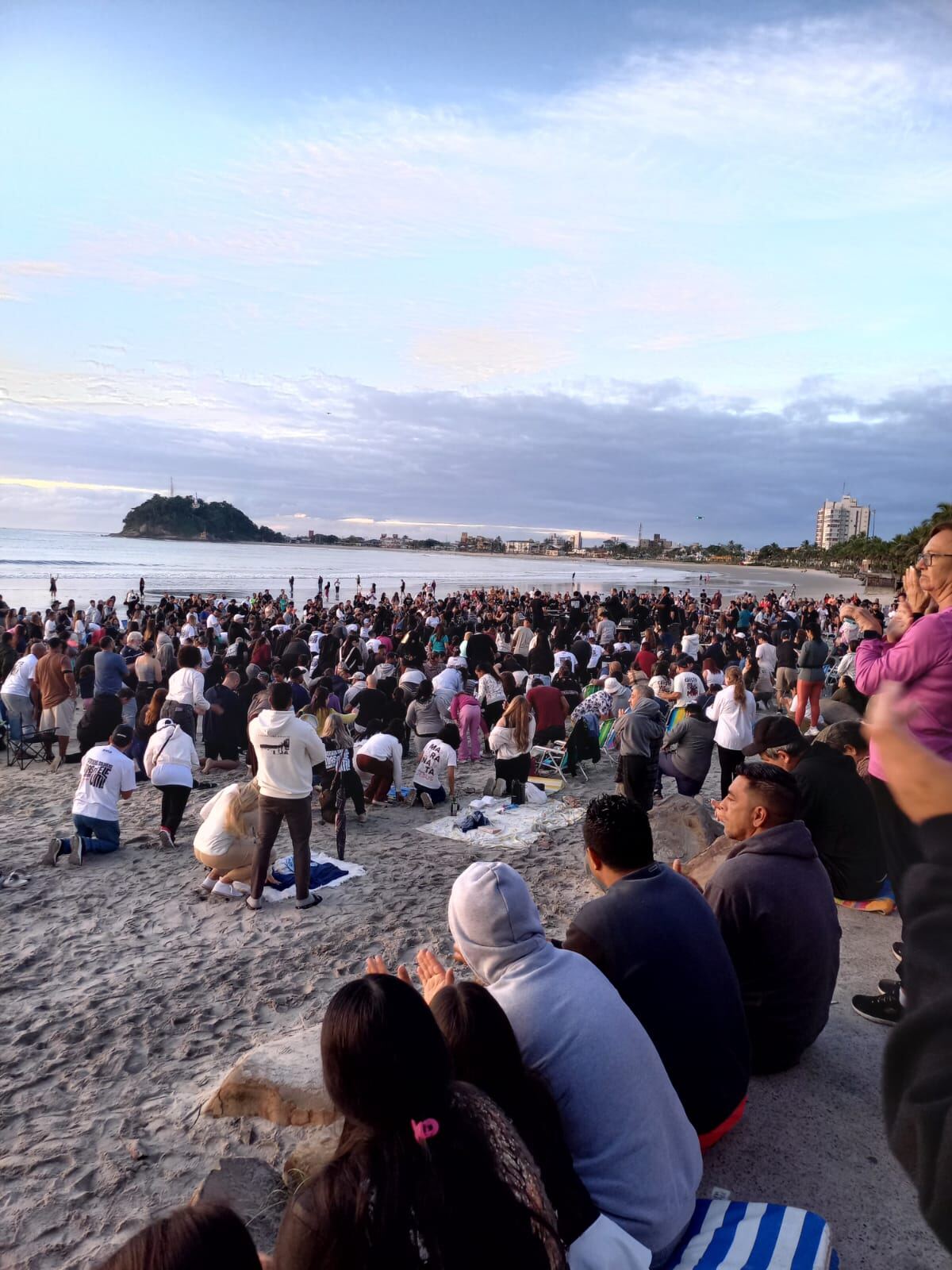 Multidão reunida na praia de Guaratuba em momento de oração pelo município